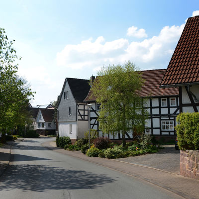 Das Foto zeigt die Haupt-Ortseingangsstraße in Wiesenfeld. Auf der rechten Seite sind alte Fachwerkhäuser zu sehen.
